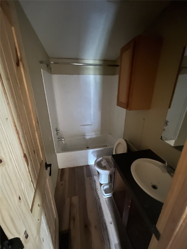 full bathroom with bathing tub / shower combination, toilet, vanity, and hardwood / wood-style flooring