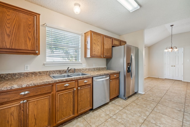 kitchen featuring a textured ceiling, stainless steel appliances, pendant lighting, an inviting chandelier, and lofted ceiling