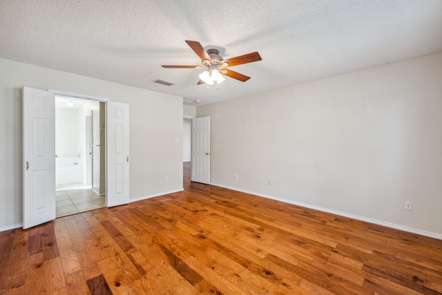 interior space featuring ceiling fan, a textured ceiling, and hardwood / wood-style flooring