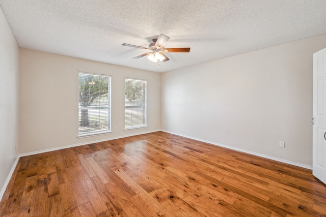 empty room featuring a textured ceiling, hardwood / wood-style flooring, and ceiling fan