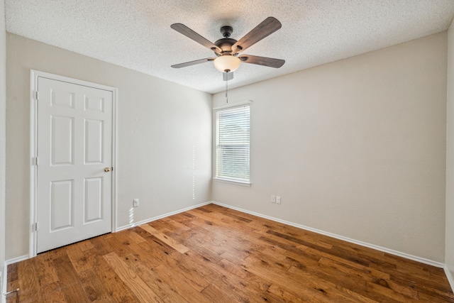 unfurnished room featuring hardwood / wood-style flooring, ceiling fan, and a textured ceiling