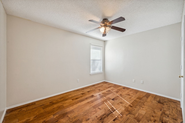 empty room featuring wood-type flooring and a textured ceiling