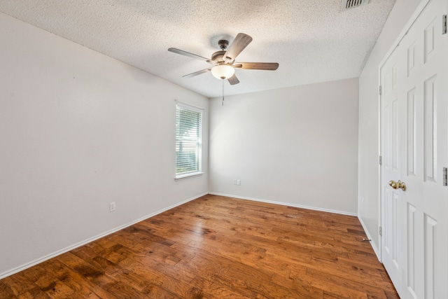 unfurnished room with ceiling fan, hardwood / wood-style floors, and a textured ceiling