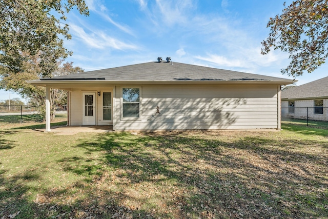 back of property with a patio area and a yard