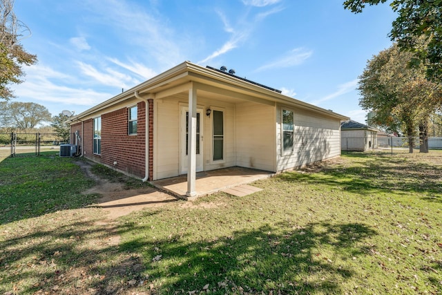 back of house with a patio area, central air condition unit, and a yard