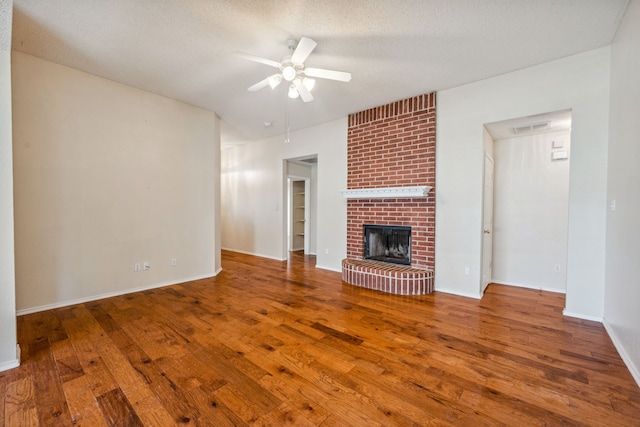 unfurnished living room featuring a fireplace, hardwood / wood-style floors, a textured ceiling, and ceiling fan