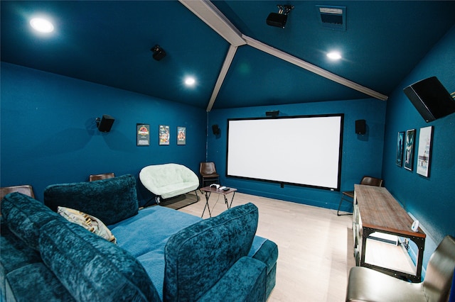 cinema with wood-type flooring and vaulted ceiling