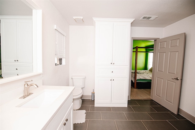 bathroom with tile patterned flooring, vanity, and toilet