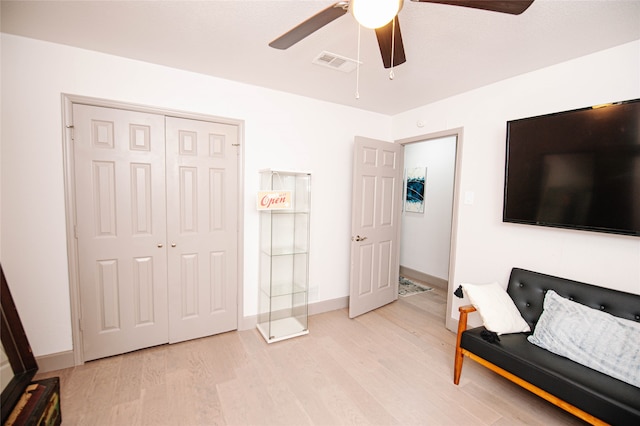 bedroom with a closet, light hardwood / wood-style floors, and ceiling fan