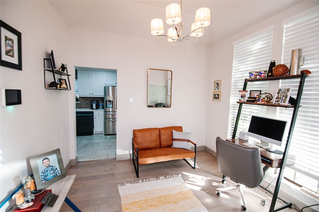 home office with light wood-type flooring and a chandelier