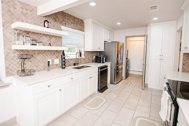 kitchen featuring white cabinets, decorative backsplash, stainless steel appliances, and sink