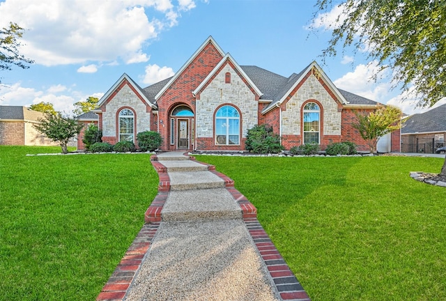 view of front of home featuring brick siding and a front yard