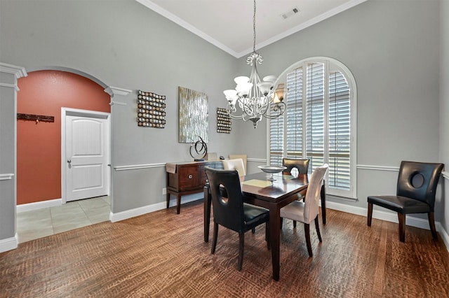 dining space featuring arched walkways, visible vents, ornamental molding, ornate columns, and an inviting chandelier