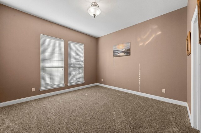 carpeted spare room with baseboards