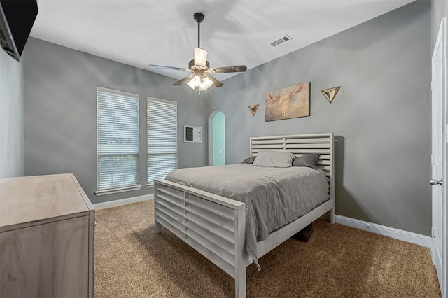 bedroom with arched walkways, visible vents, light carpet, and baseboards