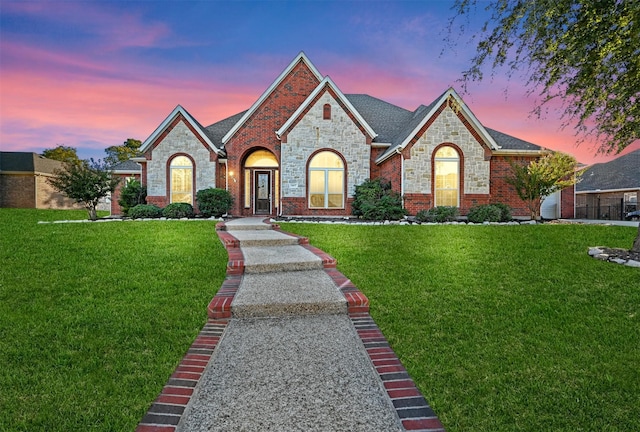 french country style house featuring a front lawn and brick siding