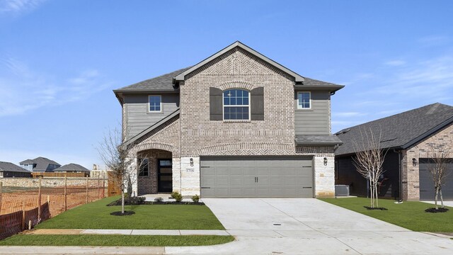 view of property featuring a garage and a front lawn