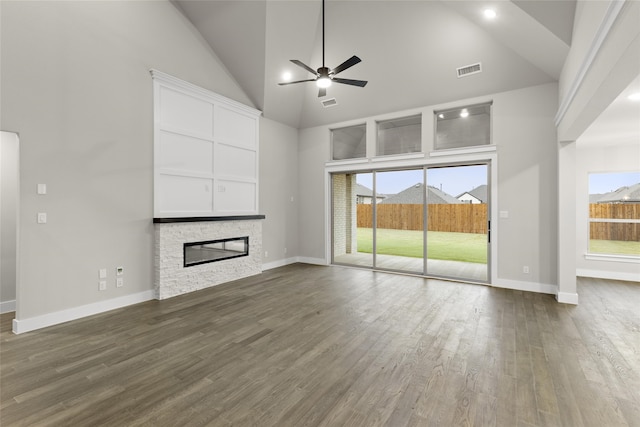 724 Stearman Ln, Fate, TX 75087 - unfurnished living room featuring a ceiling fan, dark wood-style floors, a fireplace, and high vaulted ceiling