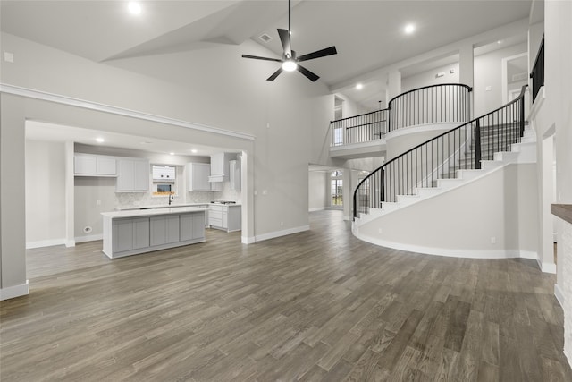 724 Stearman Ln, Fate, TX 75087 - unfurnished living room featuring stairs, high vaulted ceiling, light wood-type flooring, a ceiling fan, and recessed lighting
