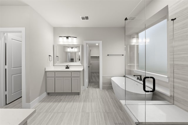 bathroom featuring shower with separate bathtub, vanity, and tile patterned floors