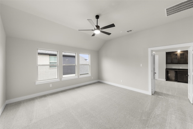 carpeted empty room featuring ceiling fan and lofted ceiling