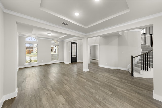 unfurnished living room featuring dark hardwood / wood-style floors, crown molding, and a tray ceiling