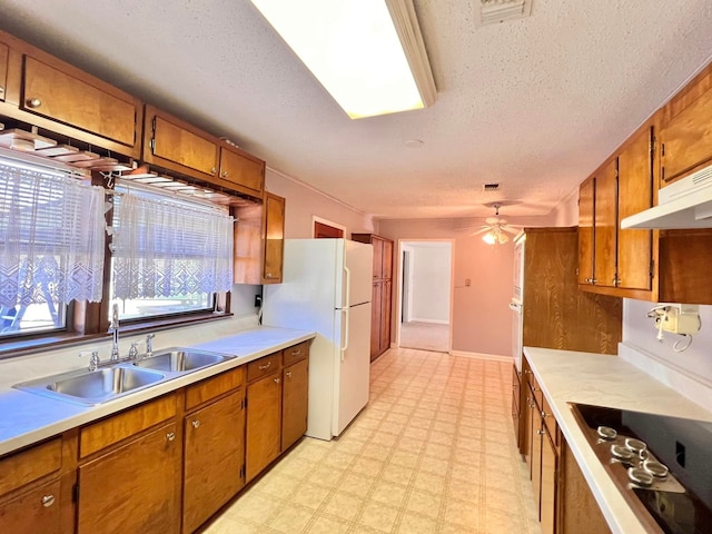 kitchen with a textured ceiling, white appliances, ceiling fan, and sink