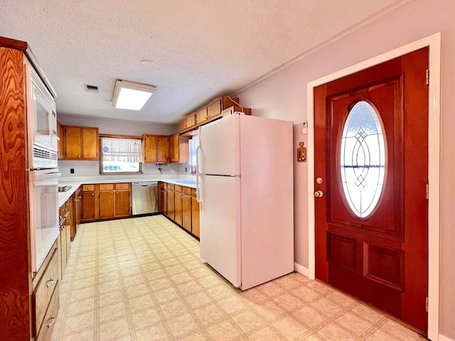 kitchen featuring a textured ceiling, sink, and white appliances