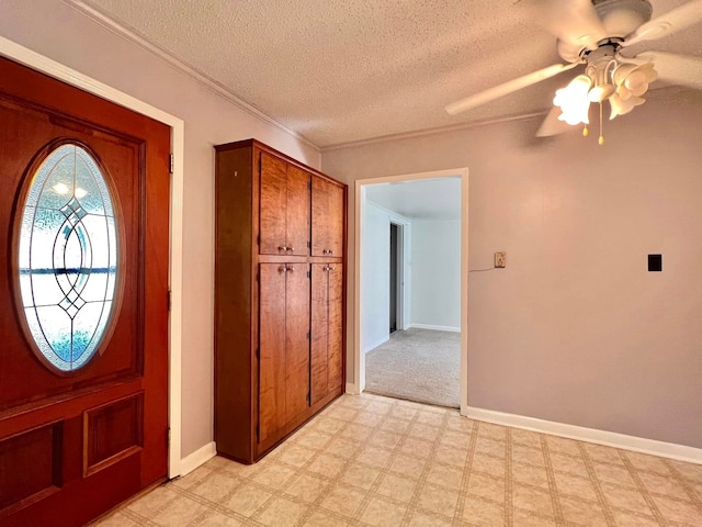 foyer entrance with ceiling fan and a textured ceiling