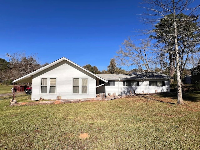 back of property featuring a carport and a yard