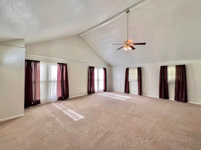 carpeted spare room with a textured ceiling, high vaulted ceiling, a wealth of natural light, and ceiling fan