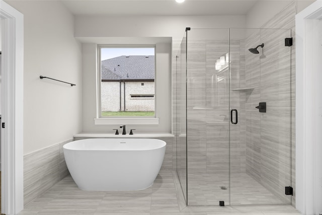 bathroom featuring tile patterned floors, tile walls, and shower with separate bathtub