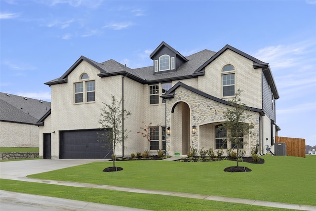 view of front of home with a front yard, a garage, and cooling unit