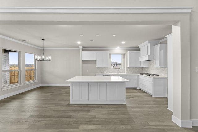 kitchen featuring white cabinets, plenty of natural light, a kitchen island, and light hardwood / wood-style flooring