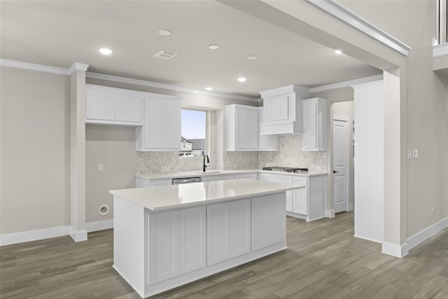 kitchen with white cabinetry, a center island, wood-type flooring, and sink