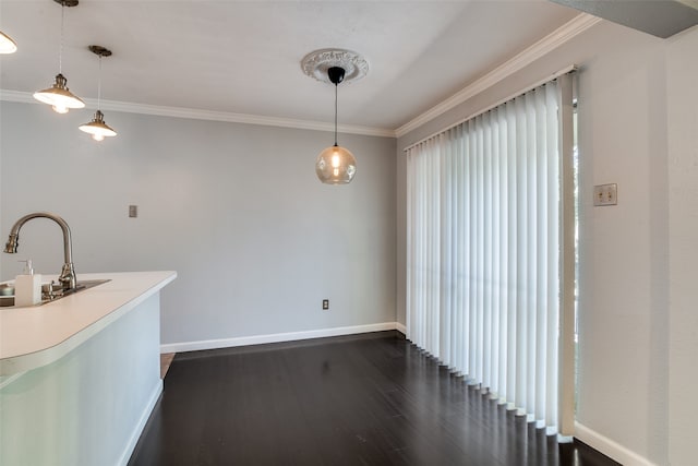 kitchen featuring sink, hanging light fixtures, dark wood-type flooring, and ornamental molding