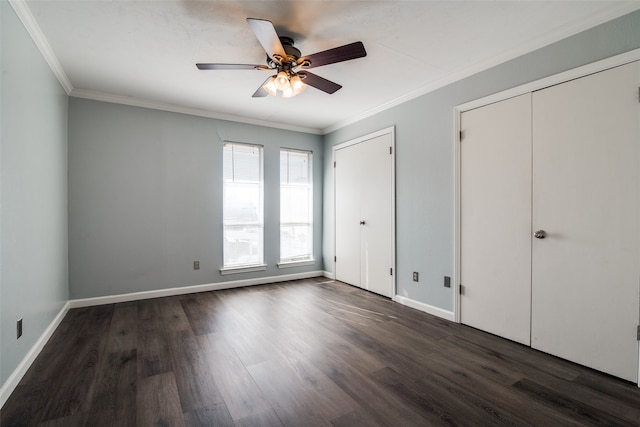 unfurnished bedroom featuring dark hardwood / wood-style flooring, two closets, ceiling fan, and crown molding