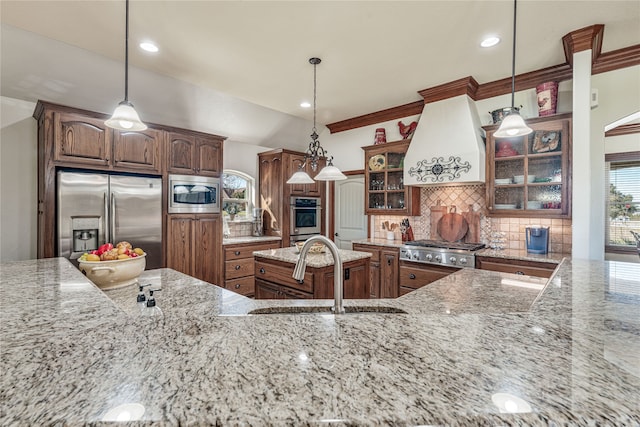 kitchen featuring appliances with stainless steel finishes, custom exhaust hood, pendant lighting, and sink