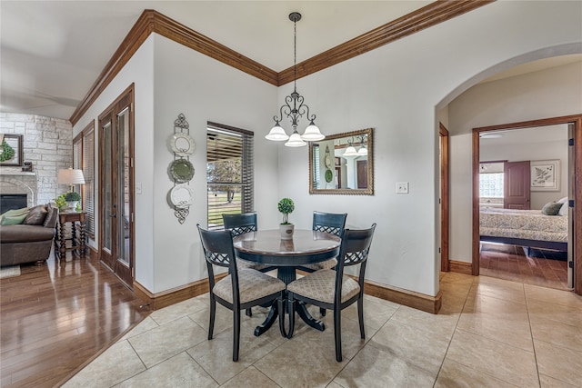 dining area featuring a wealth of natural light, crown molding, light hardwood / wood-style floors, and an inviting chandelier