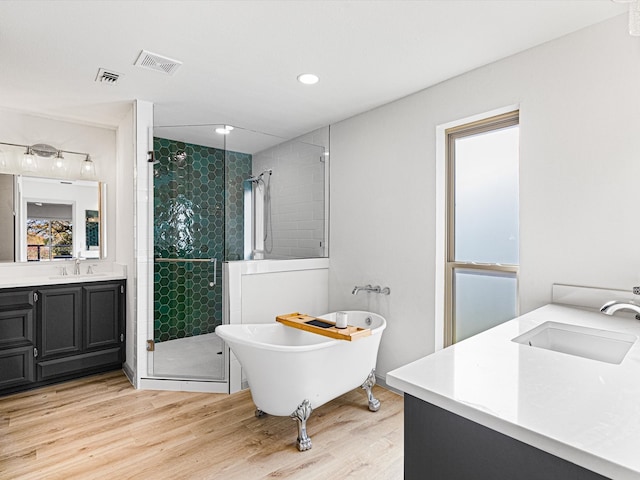 bathroom with wood-type flooring, vanity, and independent shower and bath