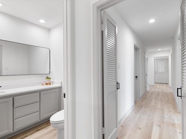 bathroom with hardwood / wood-style flooring, vanity, and toilet