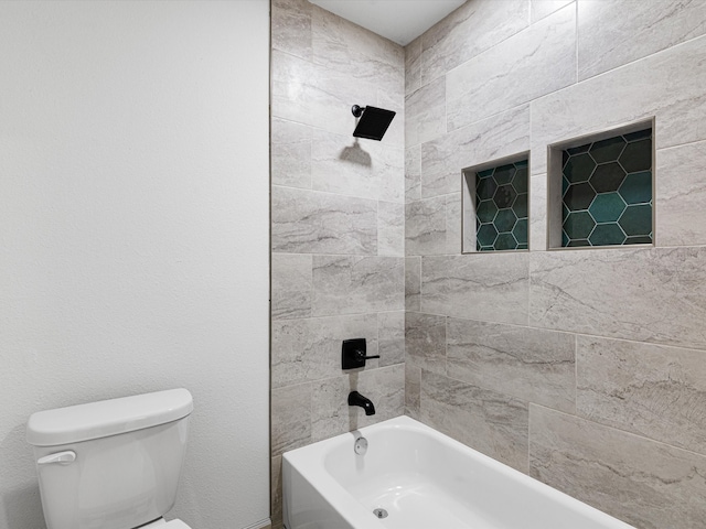 bathroom with tiled shower / bath and toilet