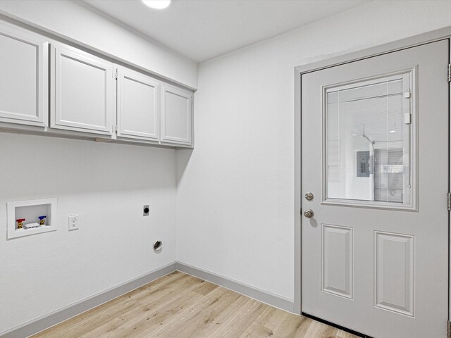 washroom with hookup for an electric dryer, washer hookup, cabinets, and light hardwood / wood-style flooring