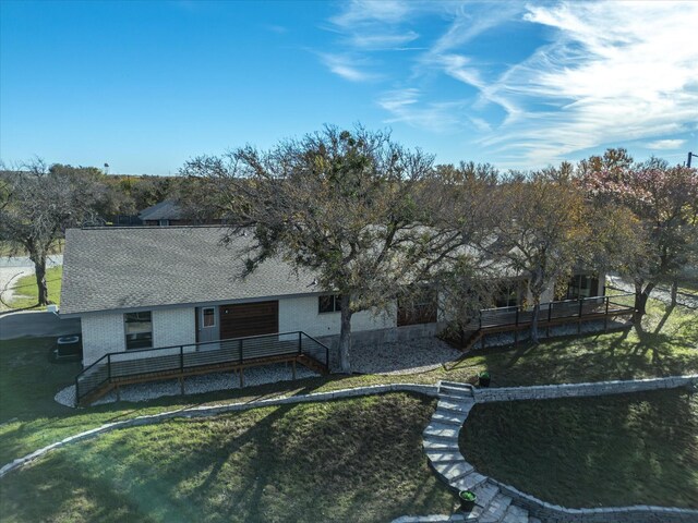 rear view of house featuring a yard and a deck