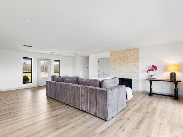 living room with a fireplace and light wood-type flooring