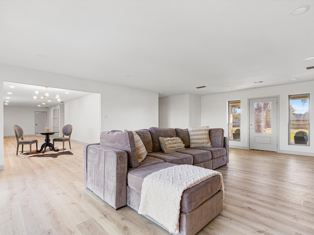 living room with light hardwood / wood-style flooring and a notable chandelier