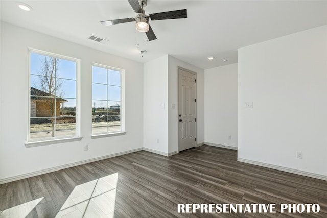 unfurnished room with dark wood-type flooring, ceiling fan, and a healthy amount of sunlight