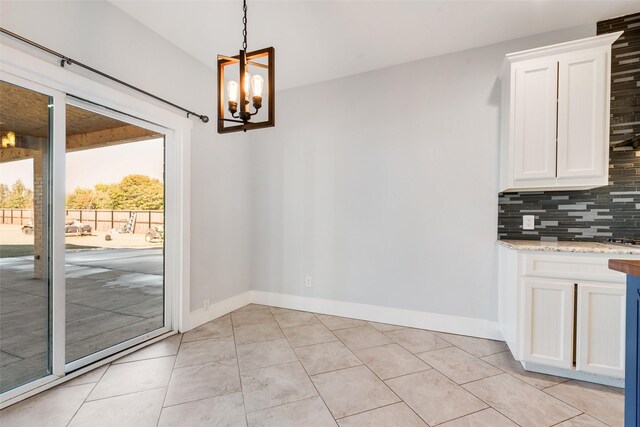 unfurnished dining area featuring a chandelier and light tile patterned floors