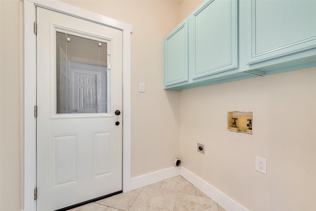 clothes washing area featuring hookup for an electric dryer, hookup for a washing machine, light tile patterned floors, and cabinets