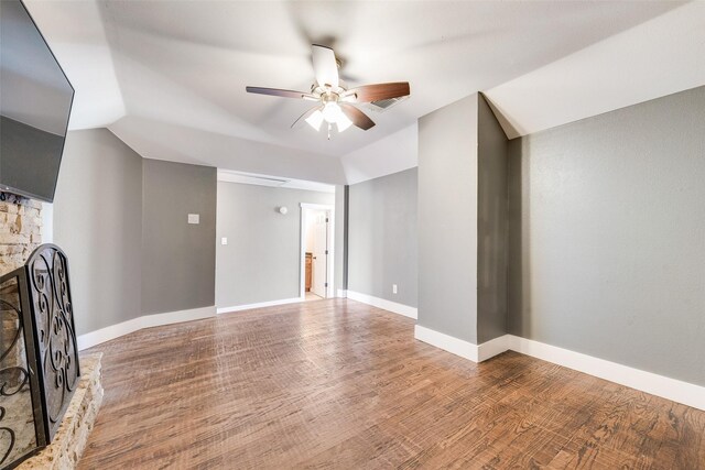 unfurnished living room featuring ceiling fan, a fireplace, wood-type flooring, and lofted ceiling